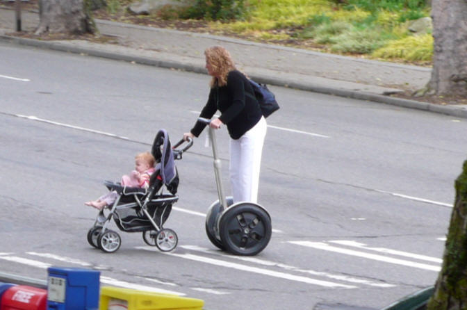 Woman pushing child on Segway